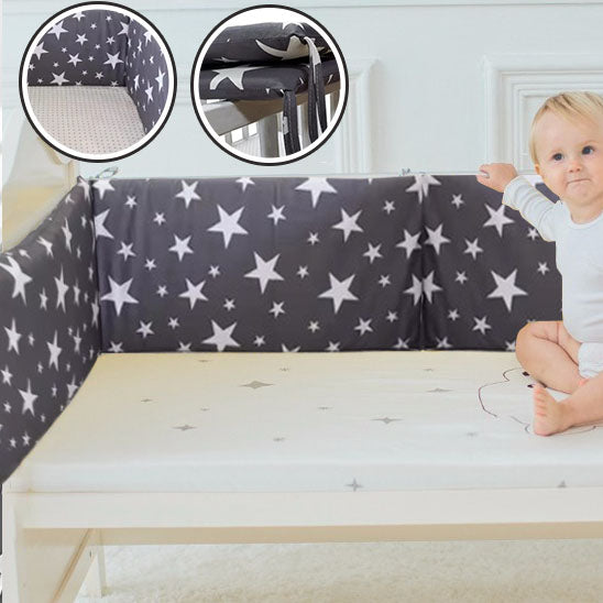 bebe assis touchant le tour de lit bebe