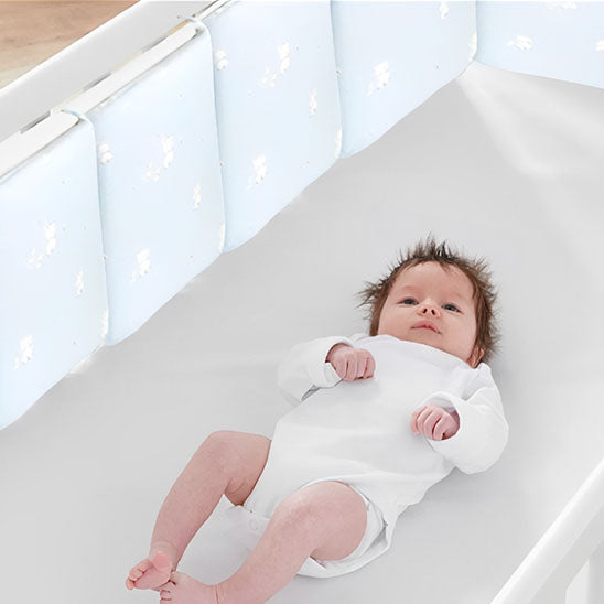 bebe couche dans le lit avec tour de lit