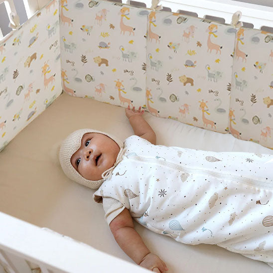 bebe dans son lit protege de son tour de lit