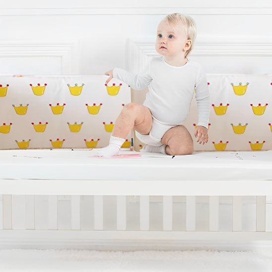 bebe sur genou touchant le tour de lit bebe