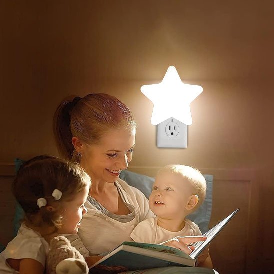 enfant et maman contents lisant avec veilleuse bebe