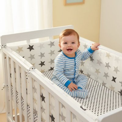 Petit garçon dans son lit à tour de lit bébé