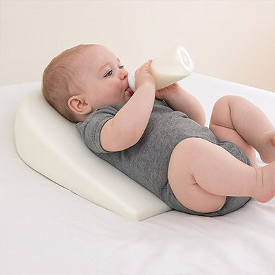 Bébé boit biberon sur oreiller pour bébé 