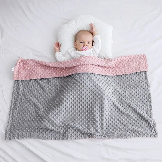 Bébé contente sous sa couverture bébé