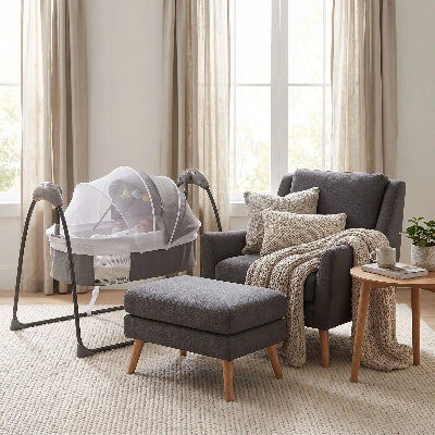 Bébé couché dans lit bébé électrique proche du canapé
