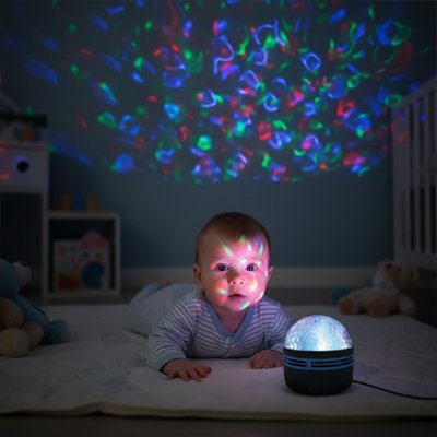 Bébé couché sur tapis regardant veilleuse projection