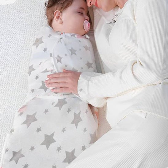 Bébé couvert par couverture emmaillotage