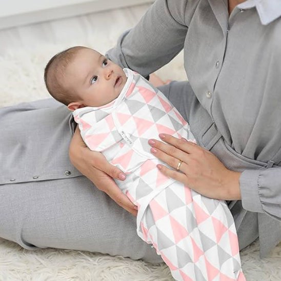 Bébé dans couverture emmaillotage regarde maman