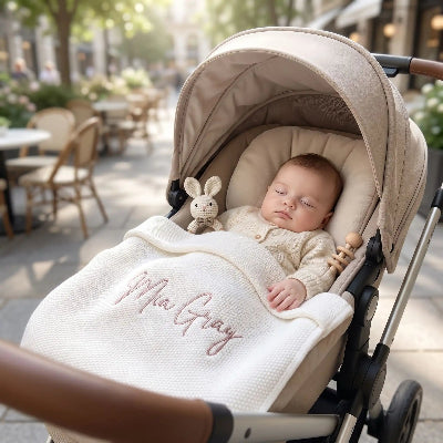 bebe dans poussette avec couveture tricotee personnalisee