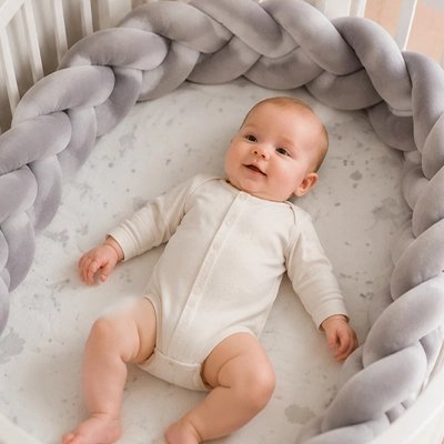 Bébé dort entouré du tresse de lit