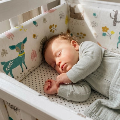 Bébé dort protégé par le tour de lit bébé