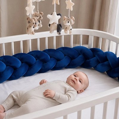 Bébé heureux dans lit avec tour de lit tresse