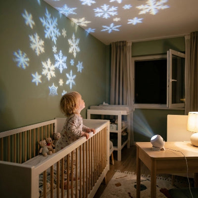 Bébé regarde la veilleuse à projection allumée