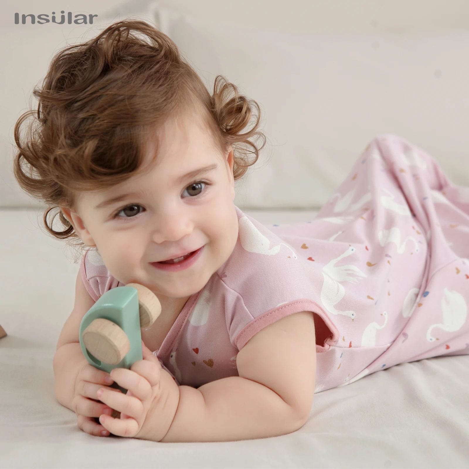 bebe souriant dans sa gigoteuse