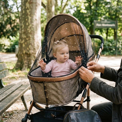 Bébé sous moustiquaire pour poussette​
