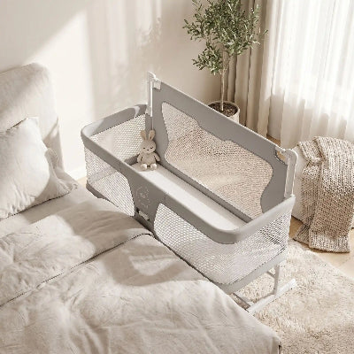 berceau pliable gris avec un doudou