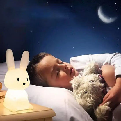 garcon dormant avec doudou en main et veilleuse bebe allume