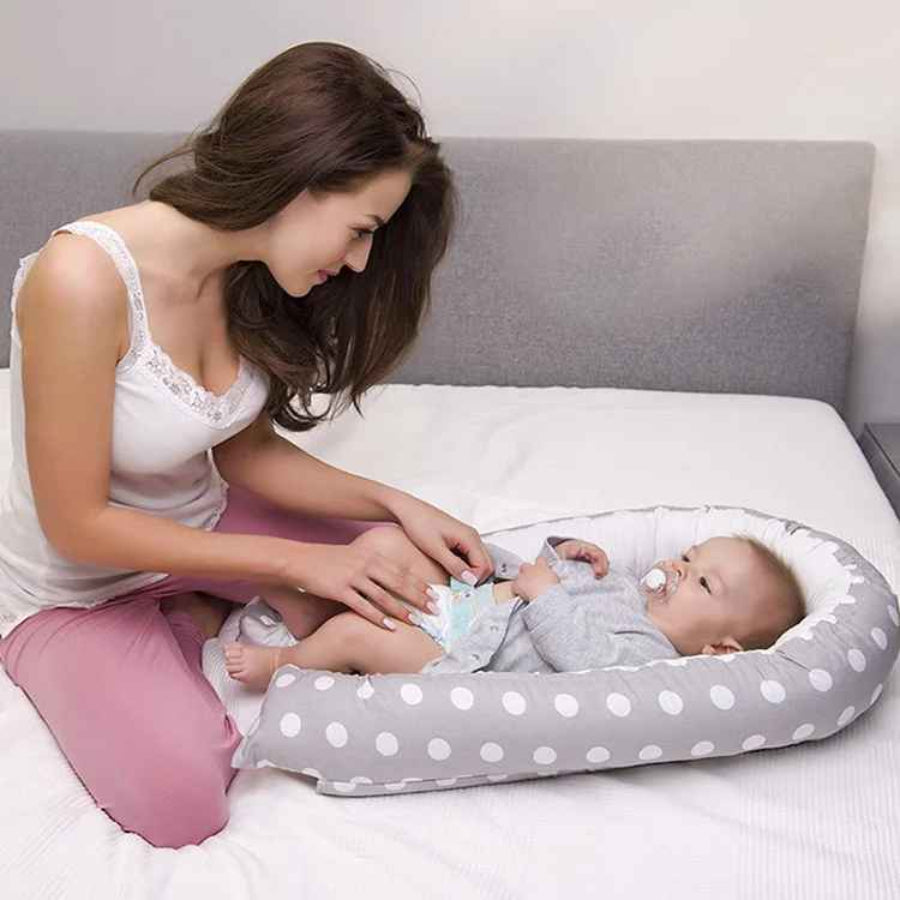 maman regarde bebe couche dans reducteur de lit pour bebe