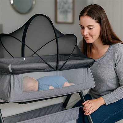 Maman regarde bebe sous moustiquaires lit bebe