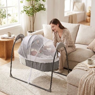 Maman sourit à bébé couché dans lit bébé électrique
