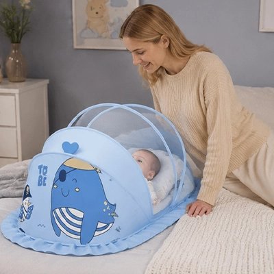 Maman sourit à bébé sous moustiquaire lit bébé