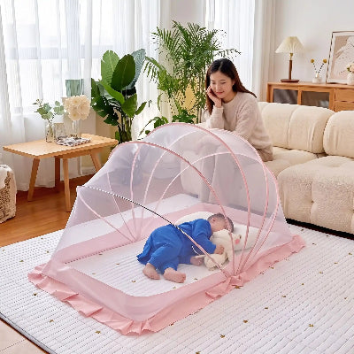 Maman surveille bébé qui dort dans moustiquaire pliante