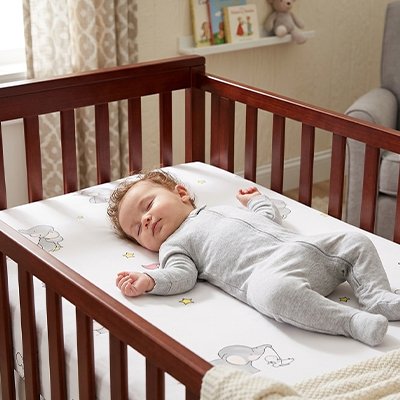 Petit garcon dort sur drap housse lit bébé 